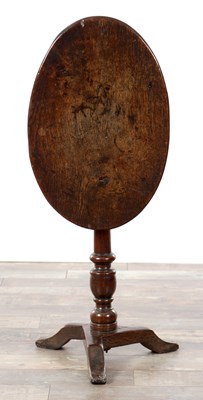 Lot 1377 - AN EARLY 18TH CENTURY OAK OVAL TILT TOP TABLE ON A TRIFORM BASE