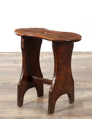 Lot 1469 - AN 18TH CENTURY ELM STOOL WITH SHAPED SEAT AND TRESTLE END SUPPORTS