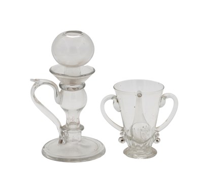 Lot 26 - AN 18TH CENTURY POSSET GLASS WITH TWIN HANDLES AND GADROONED BASE AND A 19TH CENTURY GLASS LACE-MAKERS OIL LAMP