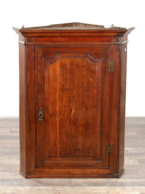 Lot 1620 - A GEORGE III OAK HANGING CORNER CUPBOARD WITH MOULDED PANEL DOOR AND SHELL INLAID CENTRE