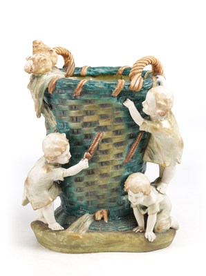 Lot 35 - A LATE 19TH CENTURY AMPHORA AUSTRIAN POLYCHROME GLAZED EARTHENWARE JARDINIERE MODELLED AS A WOVEN BASKET WITH FOUR CHILDREN