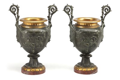 Lot 960 - A PAIR OF 19TH CENTURY FRENCH PATINATED AND GILT BRONZE TWIN HANDLED URNS ON ROUGE MARBLE BASES