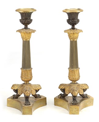 Lot 1013 - A PAIR OF 19TH CENTURY BRONZE AND GILT BRONZE REGENCY STYLE CANDLESTICKS