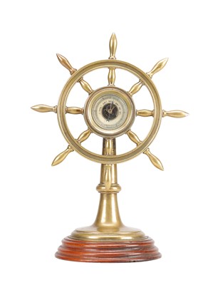 Lot 1312 - A 19TH CENTURY BRASS SHIP'S WHEEL ANEROID DESK BAROMETER ON TURNED MAHOGANY BASE