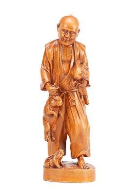 Lot 470 - A MEIJI PERIOD JAPANESE CARVED BOXWOOD OKIMONO OF A STANDING MAN WITH RABBITS