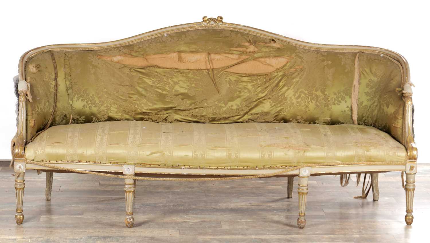Lot 1584 - A GEORGE III PARCEL GILT AND PAINTED HEPPLEWHITE STYLE THREE SEATER SETTEE