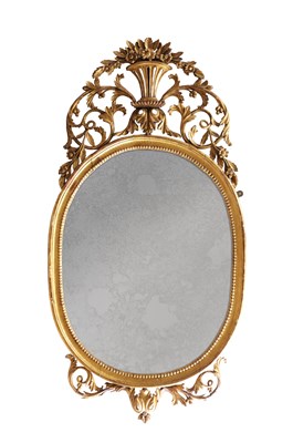Lot 1588 - A GEORGE III CARVED GILTWOOD OVAL HANGING MIRROR WITH FLOWER BASKET CRESTING