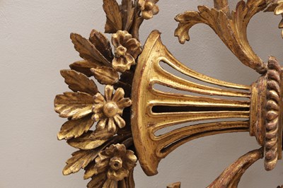 Lot 1588 - A GEORGE III CARVED GILTWOOD OVAL HANGING MIRROR WITH FLOWER BASKET CRESTING