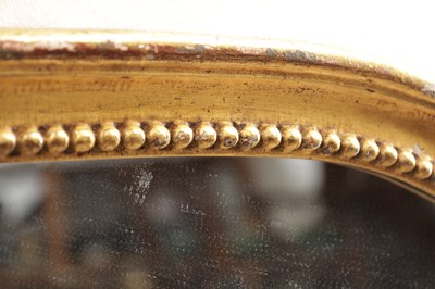 Lot 1588 - A GEORGE III CARVED GILTWOOD OVAL HANGING MIRROR WITH FLOWER BASKET CRESTING