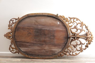 Lot 1588 - A GEORGE III CARVED GILTWOOD OVAL HANGING MIRROR WITH FLOWER BASKET CRESTING