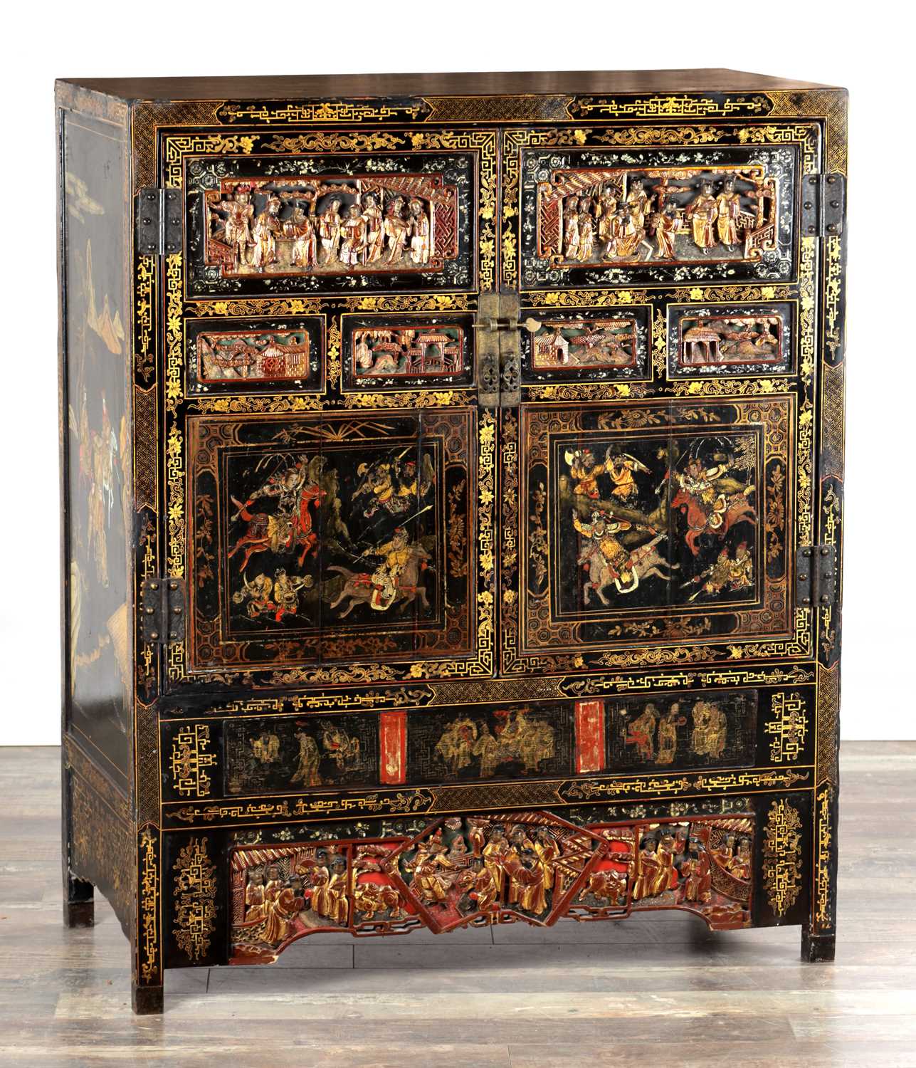 Lot 1487 - A LATE 19TH CENTURY CHINESE INLAID BLACK LACQUER CABINET WITH RELIEF CARVED GILT PANELS