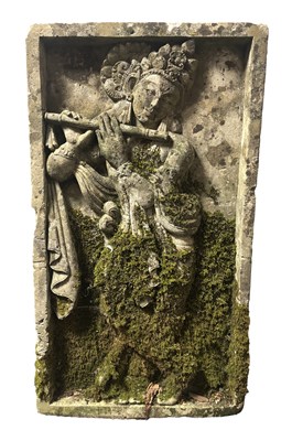 Lot 1115 - A CARVED STONE RELIEF PANEL OF A FLUTE-PLAYING DEITY