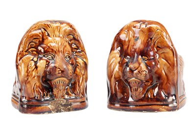 Lot 657 - A PAIR OF 19TH CENTURY STAFFORDSHIRE TREACLE GLAZED EARTHENWARE LION'S HEAD SASH WINDOW SUPPORTS