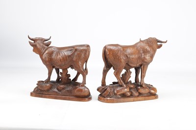 Lot 1427 - IN THE MANNER OF HUGGLER (SWISS 1834-1912) A PAIR OF 19TH CENTURY LINDEN WOOD BLACK FOREST COW AND BULL