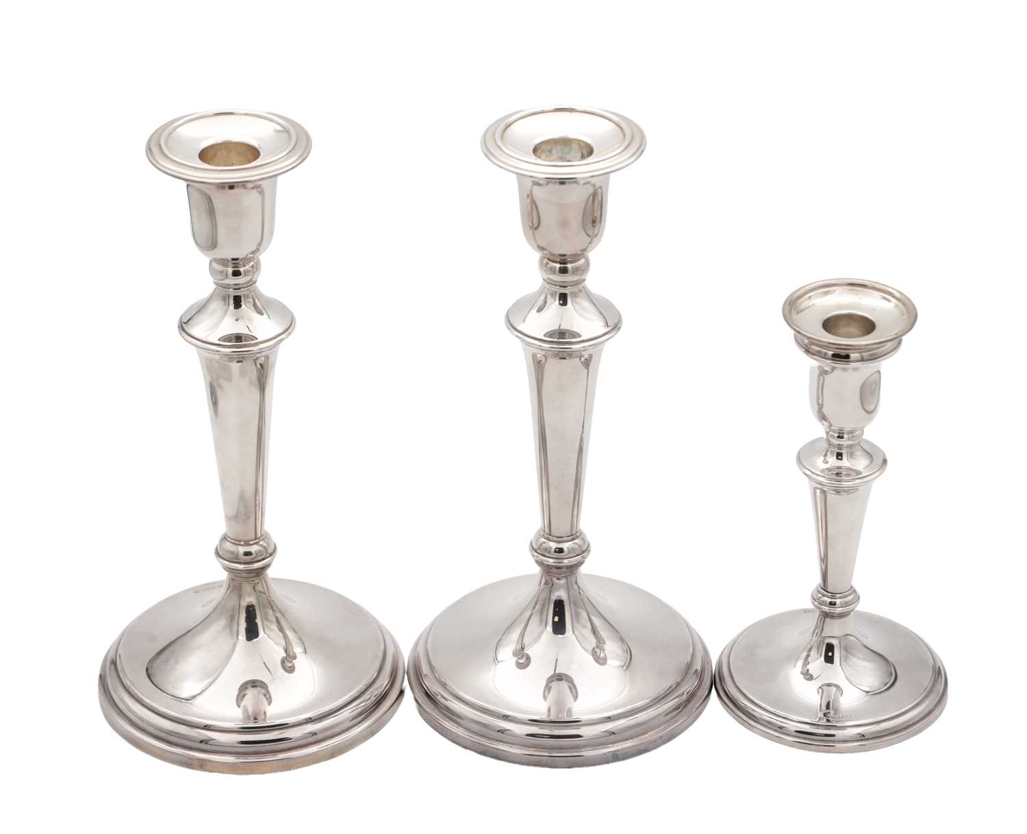 Lot 42 - A COLLECTION OF THREE EARLY 21ST CENTURY ENGLISH SILVER CANDLESTICKS BY CARRS