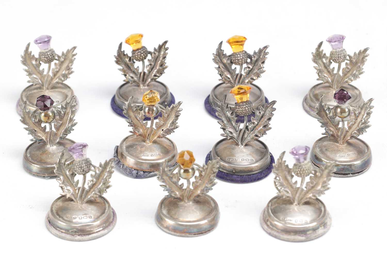 Lot 74 - A SET OF ELEVEN SCOTTISH SILVER THISTLE MENU HOLDERS
