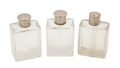 Lot 30 - A COLLECTION OF THREE GLASS SILVER-TOPPED BOTTLES