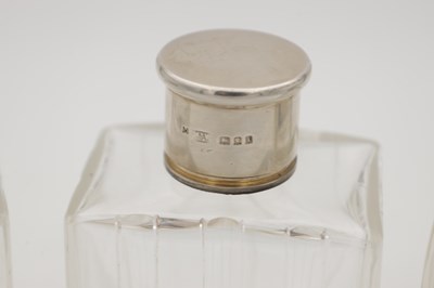 Lot 30 - A COLLECTION OF THREE GLASS SILVER-TOPPED BOTTLES
