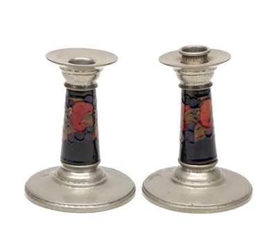 Lot A PAIR OF 20TH CENTURY MOORCROFT TUDRIC PEWTER MOUNTED POMEGRANATE PATTERN CANDLESTICKS