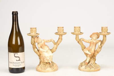 Lot A PAIR OF 20TH CENTURY ROYAL WORCESTER HADLEY PORCELAIN FIGURAL CANDLESTICKS