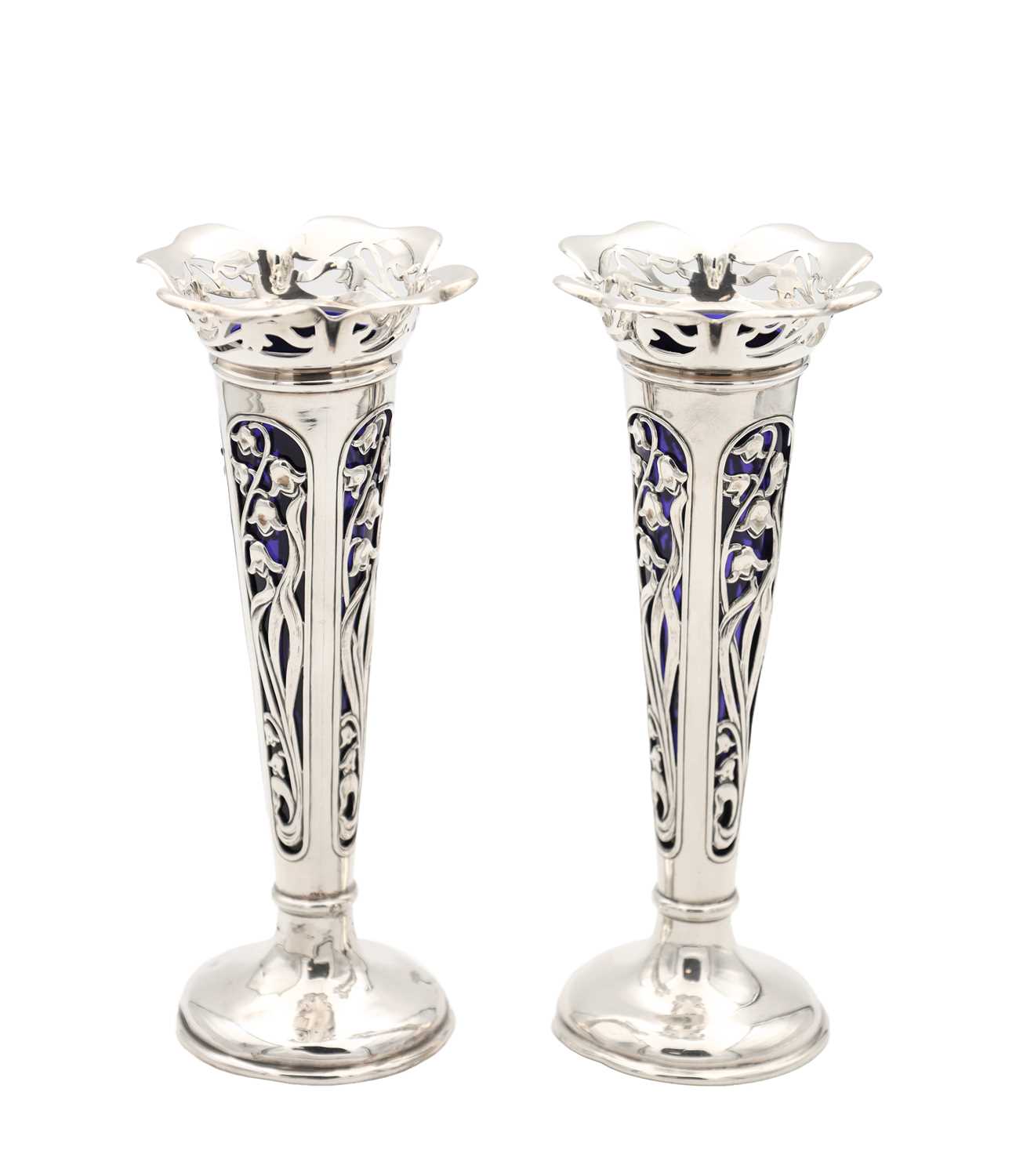 Lot A PAIR OF EDWARDIAN ENGLISH PIERCED SILVER SPILL VASES WITH BLUE GLASS LINERS