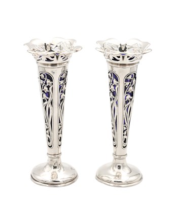 Lot A PAIR OF EDWARDIAN ENGLISH PIERCED SILVER SPILL VASES WITH BLUE GLASS LINERS