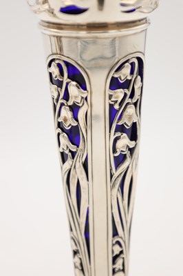 Lot A PAIR OF EDWARDIAN ENGLISH PIERCED SILVER SPILL VASES WITH BLUE GLASS LINERS