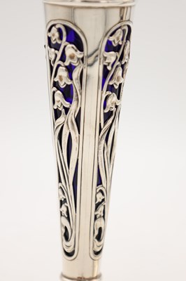 Lot A PAIR OF EDWARDIAN ENGLISH PIERCED SILVER SPILL VASES WITH BLUE GLASS LINERS