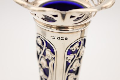 Lot A PAIR OF EDWARDIAN ENGLISH PIERCED SILVER SPILL VASES WITH BLUE GLASS LINERS