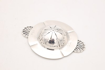 Lot AN EARLY 20TH CENTURY GEORG JENSEN DANISH SILVER TEA STRAINER AND STAND