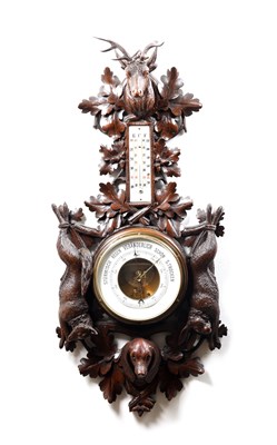 Lot 11 - A 19TH CENTURY BLACK FOREST CARVED LINDEN WOOD ANEROID HANGING BAROMETER