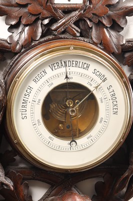 Lot 11 - A 19TH CENTURY BLACK FOREST CARVED LINDEN WOOD ANEROID HANGING BAROMETER