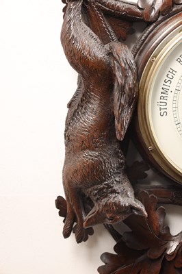 Lot 11 - A 19TH CENTURY BLACK FOREST CARVED LINDEN WOOD ANEROID HANGING BAROMETER