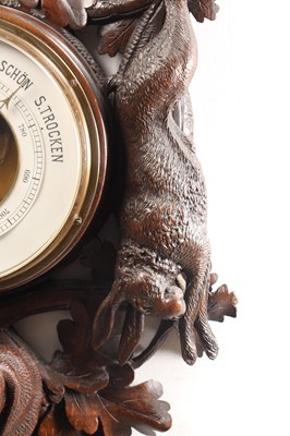 Lot 11 - A 19TH CENTURY BLACK FOREST CARVED LINDEN WOOD ANEROID HANGING BAROMETER