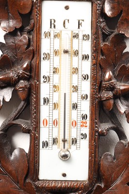 Lot 11 - A 19TH CENTURY BLACK FOREST CARVED LINDEN WOOD ANEROID HANGING BAROMETER