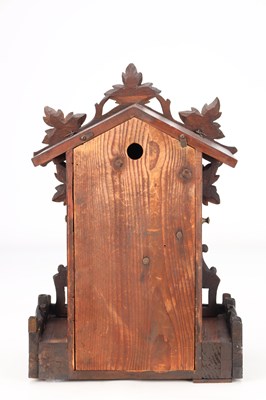 Lot 4 - A LATE 19TH CENTURY BLACK FOREST CARVED WOOD CUCKOO CLOCK