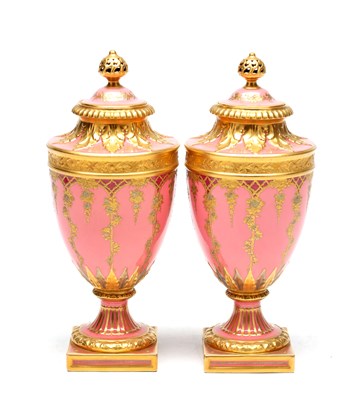 Lot DESIRE LEROY (1840-1908) A FINE PAIR OF EARLY 20TH CENTURY CROWN DERBY CORAL GROUND AND GILT LIDDED CABINET VASES