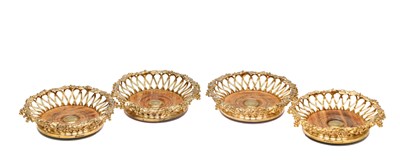 Lot A SET OF FOUR MID 19TH CENTURY GILT METAL BOTTLE COASTERS BY ELKINGTON & CO