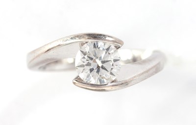 Lot 269 - A SWIRL SET SOLITAIRE DIAMOND AND PLATINUM...