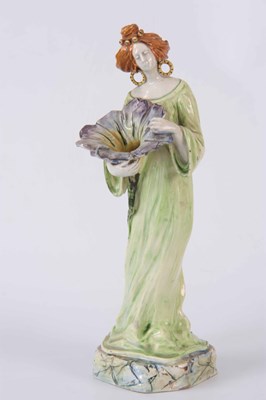 Lot 42 - AN ART NOUVEAU NOVE FAIENCE FIGURINE OF A...