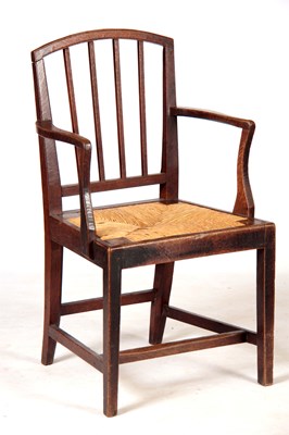 Lot 1085 - A LATE GEORGIAN OAK ARMCHAIR with a rush seat.