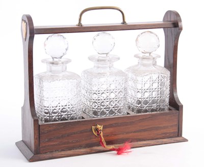 Lot 538 - AN OAK THREE BOTTLE TANTALUS with cut glass...